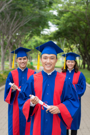 Smiling happy college graduates in the park