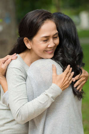 Mature woman tightly hugging her best friendの写真素材