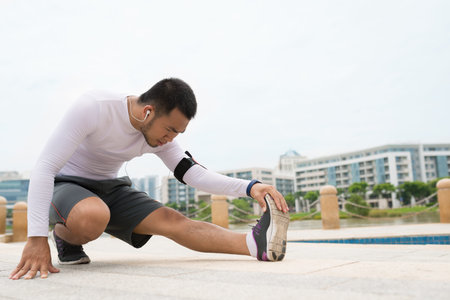 Sportsman performing stretching exercise for the legs outdoorsの写真素材