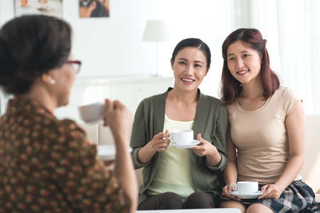 Vietnamese middle-aged woman and her daughter visiting grandmotherの写真素材