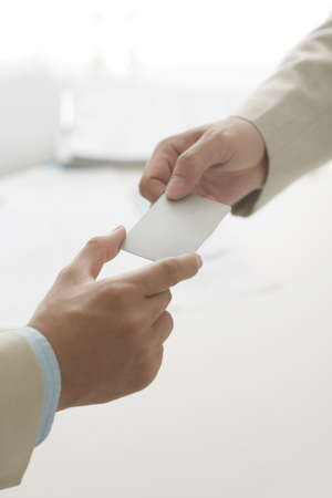 Cropped image of entrepreneur passing business card to his colleagueの写真素材