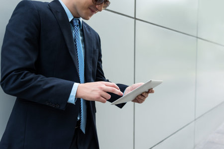 Cropped image of smiling businessman using application on tablet computer