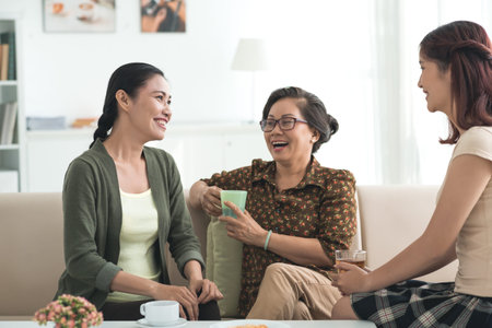 Grandmother, mother and daughter drinking tea and having good time togetherの写真素材