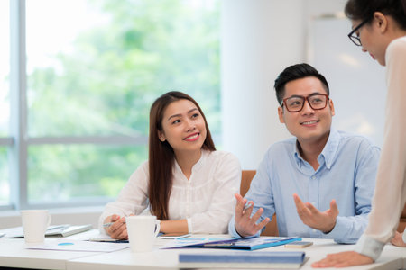 Vietnamese business colleagues discussing documents at the meetingの写真素材