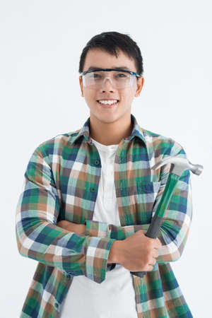 Portrait of cheerful Asian man holding claw hammerの写真素材