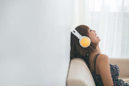 Laughing young woman in headphones listening to the radioの写真素材