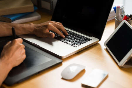 Hands of retoucher using touchpad while working on laptopの写真素材