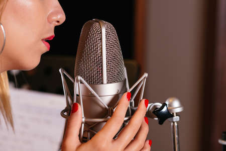 Cropped image of woman singing with microphoneの写真素材