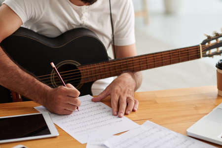 Close-up image of man writing music for new albumの写真素材