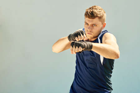 Handsome male boxer training, isolated on greyの写真素材