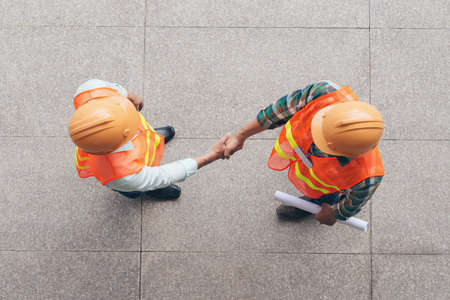 View from the top: engineer and architect shaking handsの写真素材