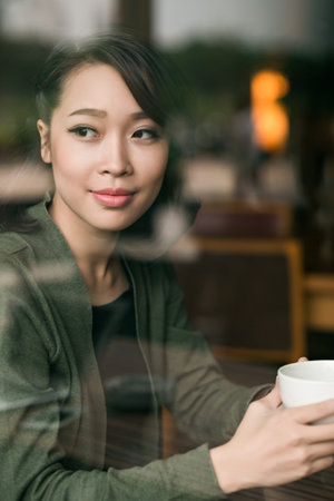 Portrait of Asian young woman having morning coffee in the cafeの写真素材