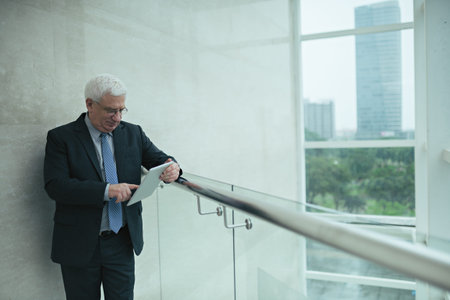 Aged businessman using application on the digital tablet