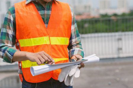 Cropped image of construction worker using tablet computer at the site
