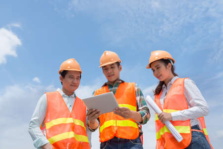 Group of Asian engineers using digital tablet outdoorsの写真素材