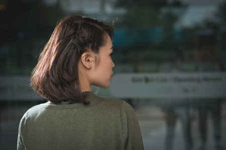 Rear view of young woman with cute braided hairstyle on short hairの写真素材