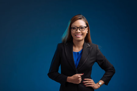 Smiling attractive business woman, isolated on blueの写真素材