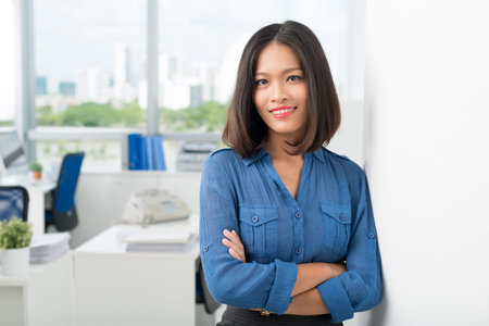 Female CEO with crossed arms standing and looking at cameraの写真素材