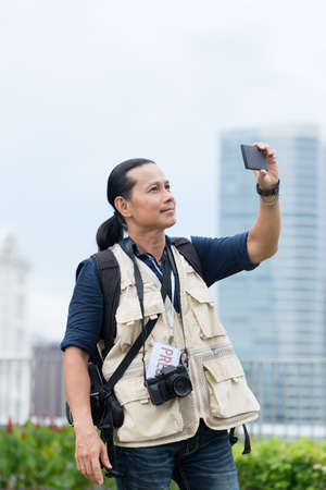 Press photographer shooting video or taking photo with a smartphoneの写真素材
