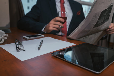 Businessman reading newspaper at his table, selective focusの写真素材