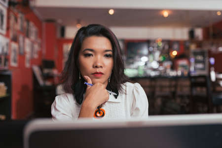 Portrait of business lady reading information on the laptop screenの写真素材