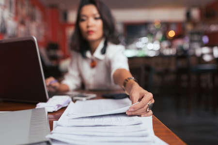 Business lady working with financial documents in her bar, selective focusの写真素材