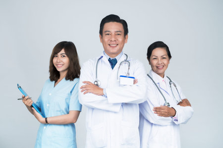 Group of smiling Asian medical workers with leader in frontの写真素材