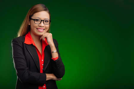 Smiling Vietnamese business lady in glasses, isolated on greenの写真素材