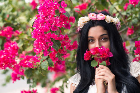 Portrait of attractive young woman with purple flowerの写真素材