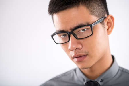 Portrait of frowning Asian businessman in eyewearの写真素材