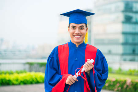 Portrait of a young man in graduate gownの写真素材