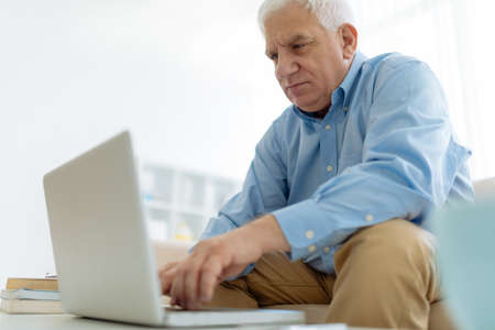 Portrait of a senior man using laptopの写真素材