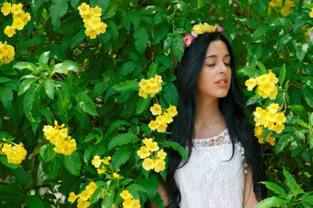 Brunette woman in white dress listening to sounds of natureの写真素材
