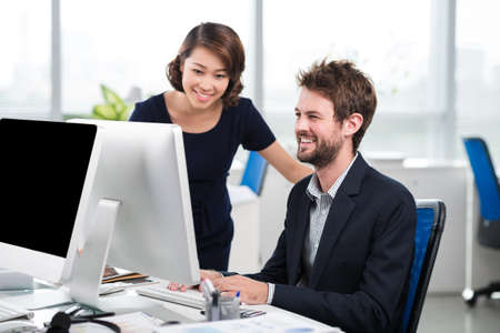 Woman helping her colleague with current taskの写真素材