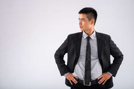 Attractive businessman with hands on hips looking awayの写真素材