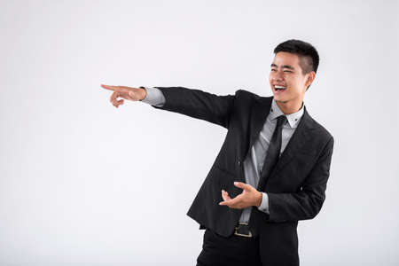 Happy businessman pointing at something isolated on white backgroundの写真素材