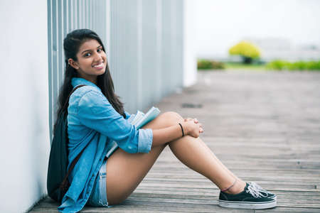 Portrait of teenage girl sitting on floor outdoorsの写真素材