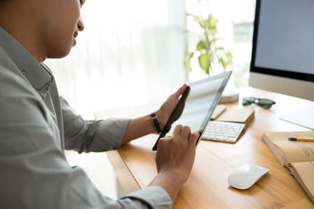 Young man using application on digital tablet, selective focusの写真素材