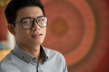Portrait of smiling Vietnamese man wearing glassesの写真素材