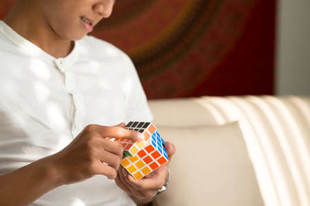 Ho Chi Minh City, Vietnam  May 14, 2015: Man solving Master Cube, variation of Rubiks cube, invented by Peter Sebestenyのeditorial素材