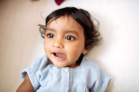 Face of innocent little girl lying in bedの写真素材