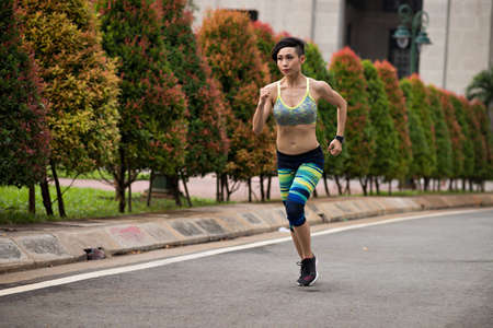 Young Vietnamese woman training for marathon runの写真素材