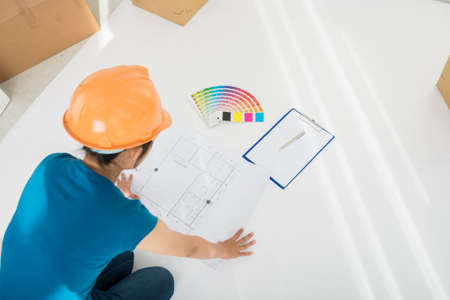 Designer looking at plan of the building before workの写真素材