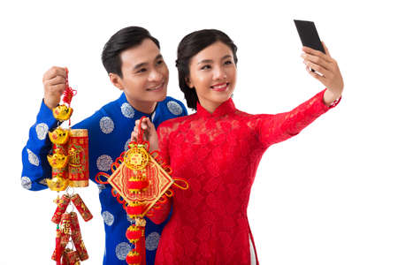 Vietnamese couple taking selfie with Tet decorationsの写真素材