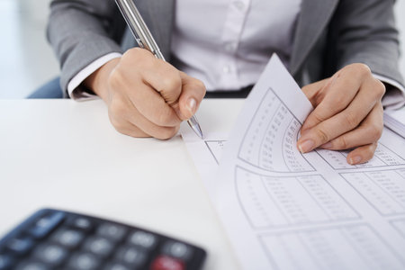 Hands of female bookkeeper working with financial documents