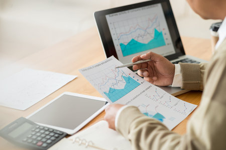 Hands of financial manager working with graphs and charts
