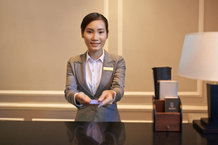 Smiling receptionist giving electronic key to the guestの写真素材