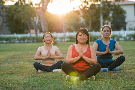 Aged women performing asana at sunsetの写真素材