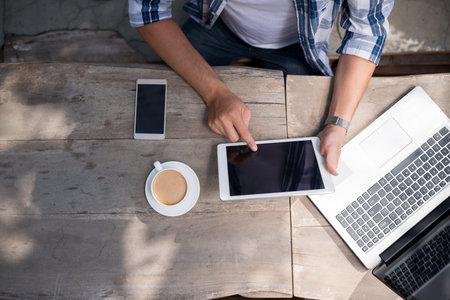 Man drinking coffee and using application on digital tablet, view from aboveの写真素材