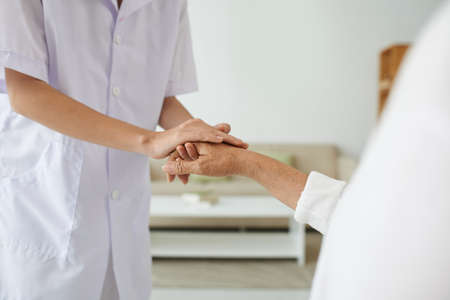 Senior female hand in that of supporting nurseの写真素材